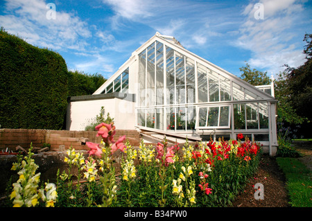 Ein Gewächshaus im Garten des Falkland Palace - Schottland, mit Blumen im Vordergrund. Stockfoto