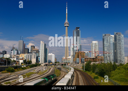 FAHREN Sie Züge verlassen auf Eisenbahnkorridor für Ende der Arbeit pendeln von der Innenstadt von Toronto mit Hochhaus-Türme und CN Tower Stockfoto