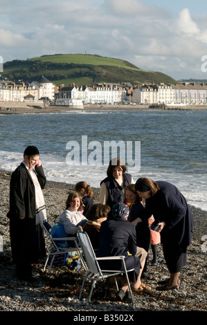 orthodoxe jüdische Familien im Sommerurlaub am Strand in Aberystwyth Wales UK Stockfoto