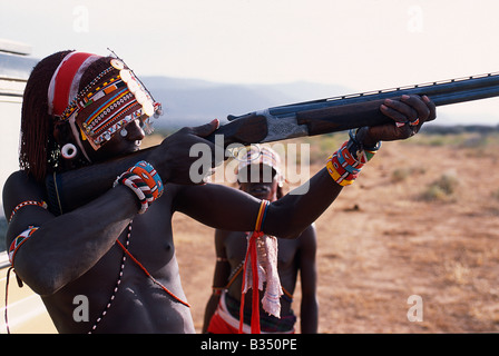 Kenya, Samburu. Samburu Moran (Krieger) versucht das Gefühl von einer Schrotflinte am Ende ein Vogelschießen Safari. Stockfoto