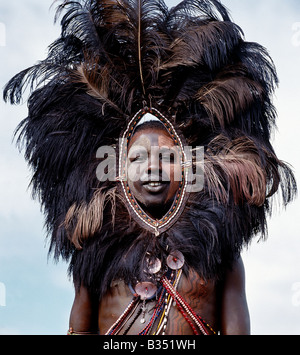 Kenia, Trans-Mara, Lolgorien. Ein Massai-Krieger, Gesicht und Körper verziert mit rotem Ocker und Lehm, trägt einen Strauß Feder Kopfschmuck. Diese einzigartigen Schmuck wurde einmal getragen von Krieger in den Kampf und wurde wahrscheinlich entwickelt, um einen Feind zu erschrecken. Stockfoto