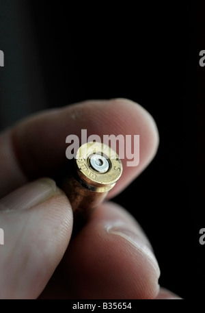 Finger halten Messing 9mm Kugel Fall gefeuert Stockfoto