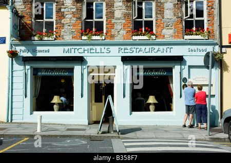 Menschen betrachten das Menü im Fenster ein Restaurant in der Innenstadt von Clifden, Connemara, County Galway, Irland Stockfoto