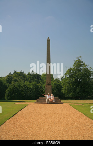 Ein Mann und eine Frau ruht am Fuße des steinernen Obelisken auf dem Gelände des Kingston Lacey House in der Nähe von Wimborne Minster, Dorset UK Stockfoto