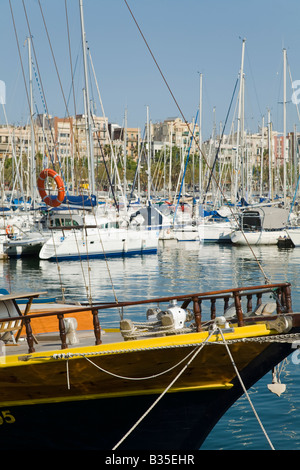 Spanien Barcelona Segelboote angedockt im Marina Port Vell Hochhäuser und Residenz Gebäude im Hintergrund von Hafengebiet Stockfoto