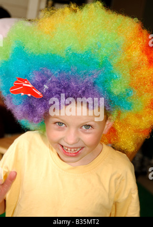 Portrait eines jungen tragen eine bunte Perücke und lächelnd Stockfoto