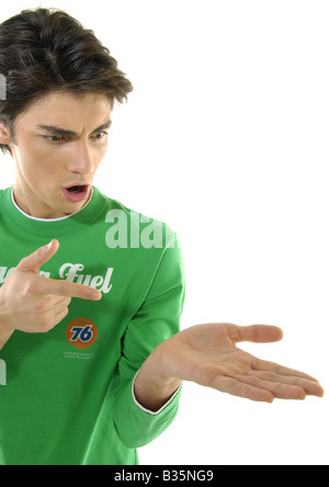 Nahaufnahme eines jungen Mannes in Richtung seiner Hand und sah geschockt Stockfoto