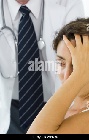 Frau mit Kopf, wegsehen, Arzt im Hintergrund Stockfoto