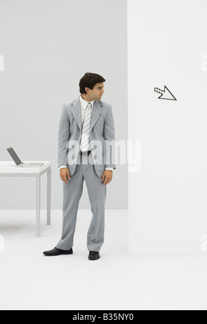 Geschäftsmann im Büro stehen, Blick in die Computer-Cursor Weg zeigen Stockfoto