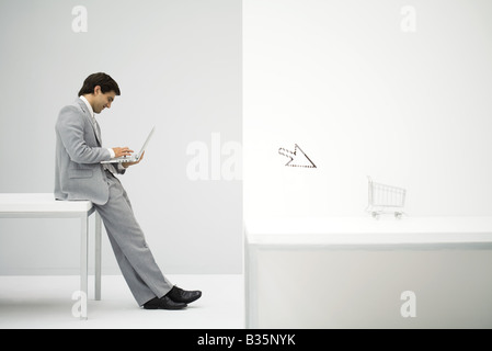 Geschäftsmann, sitzen am Schreibtisch, Einkaufen, online, shopping Cart und Cursor im Vordergrund Stockfoto