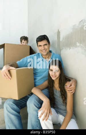 Vater und Teenager Tochter Stiegenhaus mit Kartons, junge versteckt im Hintergrund Stockfoto