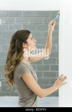 Frau Malerei Türrahmen, Seitenansicht Stockfoto