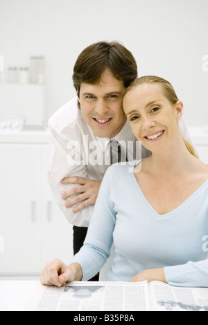 Paar lächelnd in die Kamera zusammen, Frau, Mann beugte sich über ihre Schulter Stockfoto
