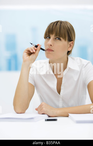 Frau nach oben und halten Sie Stift bis zur Wange Stockfoto