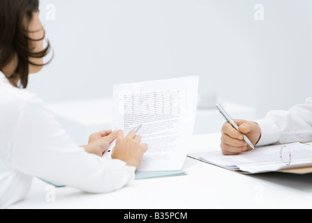 Frau hinterfragen Vertrag, Dokument in der Sammelmappe, Mann beschnitten Ansicht Stockfoto