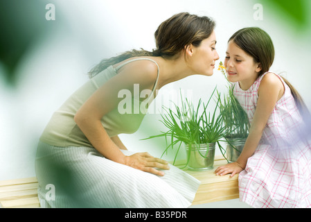 Frau und Tochter riechende Blume Zweig zusammen Stockfoto