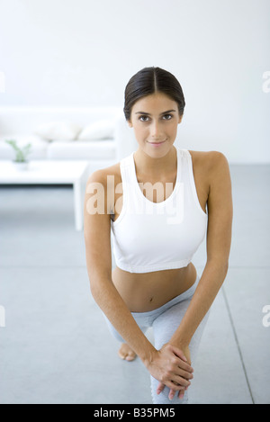 Frau machen Ausfallschritte, lächelnd in die Kamera Stockfoto