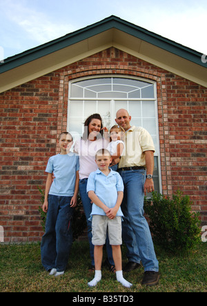 Porträt eines Mitte Erwachsenen Paares mit ihren drei Kindern stehen und Lächeln Stockfoto