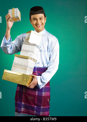 Malaysischer Mann hält Geschenk auf der anderen Seite Stockfoto