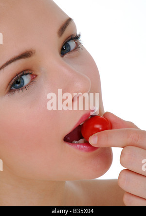 Nahaufnahme einer jungen Frau Essen einer Kirschtomate Stockfoto