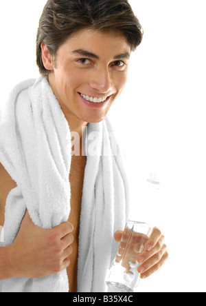 Porträt eines jungen Mannes hält eine Flasche Wasser und lächelnd Stockfoto