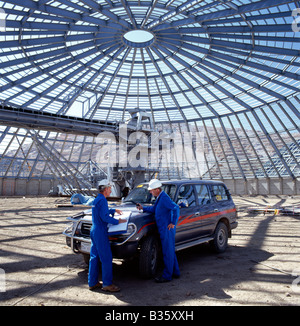 Ingenieure prüfen Zeichnungen, Zementanlage im Bau in der Wüste Bishah, Saudi-Arabien Stockfoto