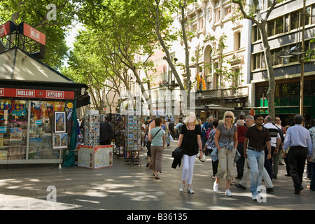 Spanien Barcelona Menschenmenge gehen Sie Las Ramblas mit Souvenir-Kiosk-Gebäude und Bäume Stockfoto