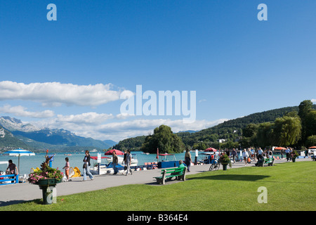 Touristen zu Fuß entlang der Promenade am Ufer des Lac d ' Annecy, Annecy, Französische Alpen, Frankreich Stockfoto