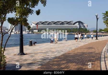 Menschen Flanieren entlang der Uferpromenade der Stadt Fukuoka mit Marine Messe Convention Center Gebäude im Hintergrund Stockfoto