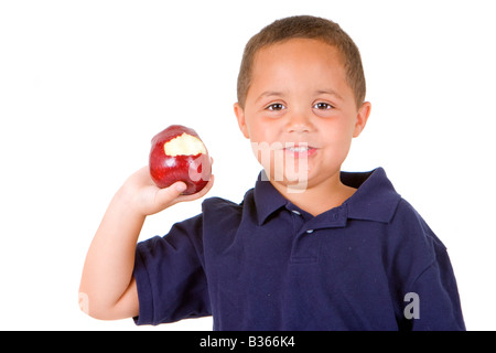 Junge Latino Boy hält einen leuchtenden roten Apfel auf dem weißen Hintergrund isoliert Stockfoto