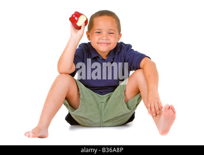 Junge Latino Boy sitzen und halten einen leuchtenden roten Apfel auf dem weißen Hintergrund isoliert Stockfoto