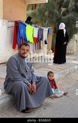 Ägyptischen Mann sitzt auf Pflaster mit kleinen Kind neben ihm Altstadt Ed Dahar Region Hurghada Stockfoto