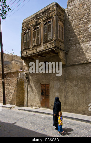 Syrer zu Fuß unter kunstvollen Detail auf einen Überhang von einem Haus in der Altstadt von Aleppo Syrien Stockfoto