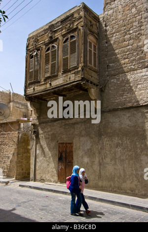 Syrer zu Fuß unter kunstvollen Detail auf einen Überhang von einem Haus in der Altstadt von Aleppo Syrien Stockfoto