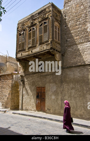 Syrer zu Fuß unter kunstvollen Detail auf einen Überhang von einem Haus in der Altstadt von Aleppo Syrien Stockfoto