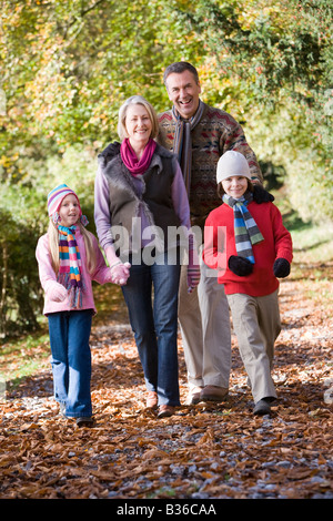 Großeltern mit Enkelkindern im Freien im Park und lächelnd zu Fuß Stockfoto