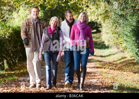 Zwei Paare im Freien im Park spazieren und lächelnd Stockfoto