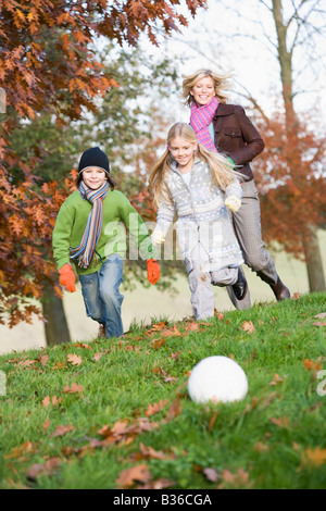 Mutter im Freien im Park mit zwei kleinen Kindern Fußball spielen und Lächeln (Tiefenschärfe) Stockfoto