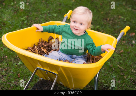 Babysitter im Freien in Schubkarre lächelnd (Tiefenschärfe) Stockfoto