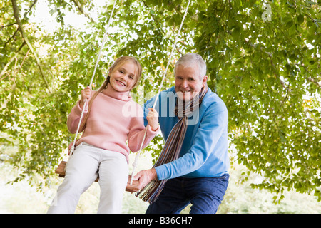 Großvater drängen Enkelin auf Swing und lächelnd (Tiefenschärfe) Stockfoto