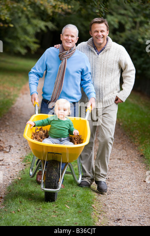 Großvater und Vater im freien Schubkarre Enkel einschieben und lächelnd (Tiefenschärfe) Stockfoto