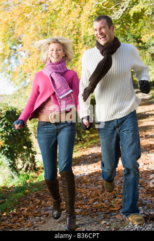 Paar im freien laufen weg im Park lächelnd (Tiefenschärfe) Stockfoto