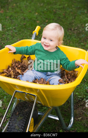 Babysitter im Freien in Schubkarre lächelnd (Tiefenschärfe) Stockfoto