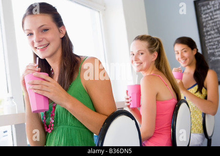 Drei junge Frauen, die ein kaltes Getränk in einer cafeteria Stockfoto