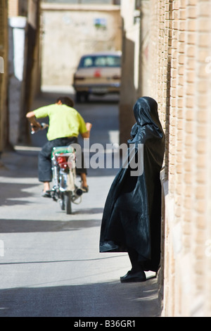 Frau trägt ein Tschador beobachten einen Motorrad-Pass in den Straßen von Shiraz, Iran Stockfoto