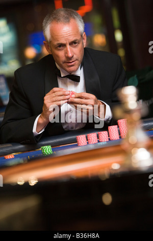 Mann im Casino Roulette spielen Holding Chips (Tiefenschärfe) Stockfoto