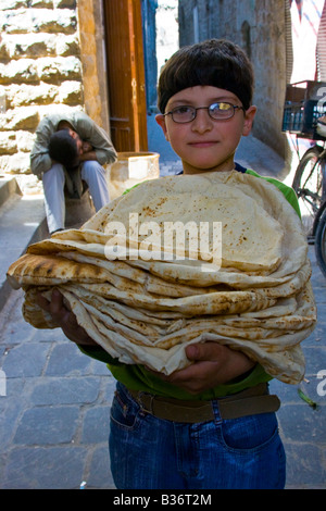 Jungen tragen frisches Brot aus einem Geschäft in der Altstadt von Aleppo Syrien Stockfoto