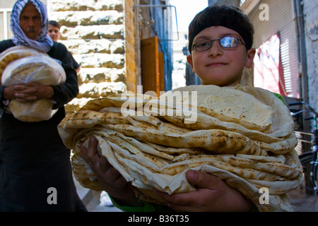 Jungen tragen frisches Brot aus einem Geschäft in der Altstadt von Aleppo Syrien Stockfoto