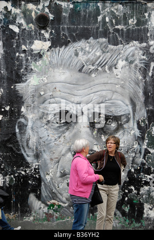 Zwei Touristen stehen vor großen Wandbild von Samuel Beckett in Blenheim Crescent, Portobello Road, London Stockfoto