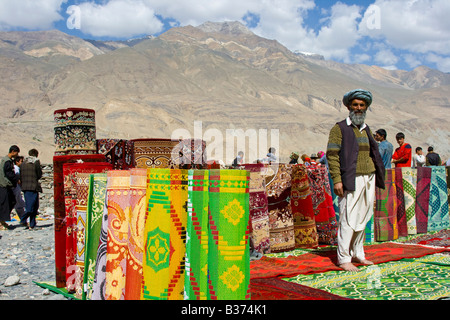 Afghanischer Mann verkaufen Teppiche und Läufer auf dem Cross-Border-Markt in der Nähe von Ishkashim Tadschikistan Stockfoto